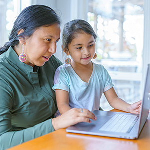 Mom and daughter looking at laptop screen