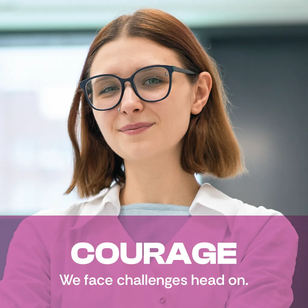 Courage. We face challenges head on. A photo of a young woman staring straight at you with a facial expression of confidence. Courage. We face challenges head on. A photo of a young woman staring straight at you with a facial expression of confidence.