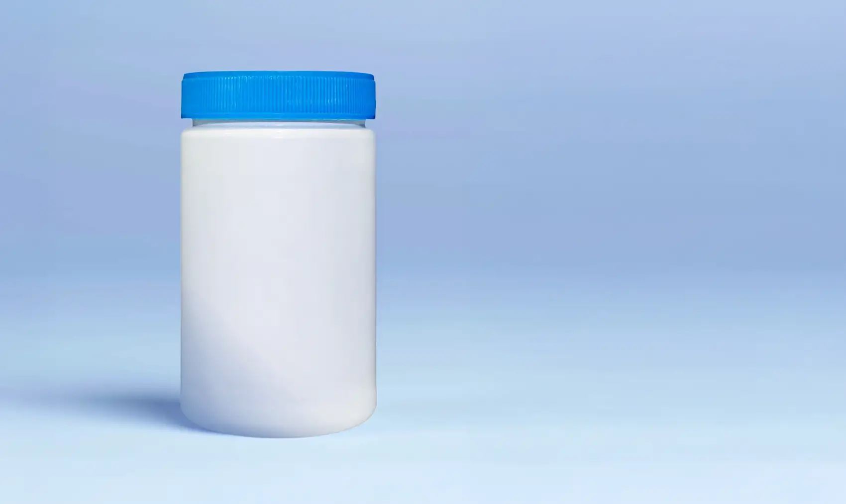 Plain white plastic jar with a blue lid on a light blue background.