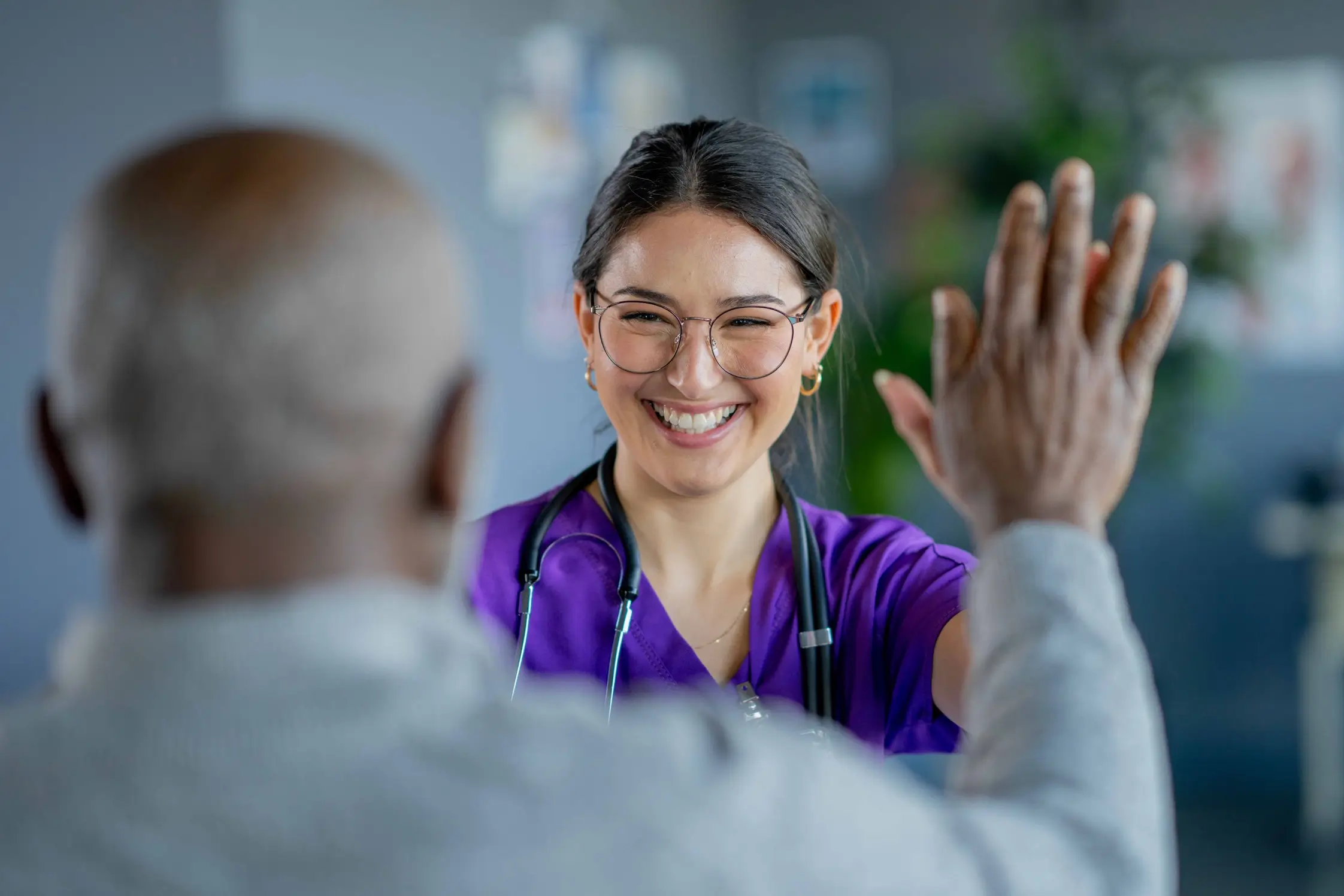 Healthcare provider smiling and high-fiving another person