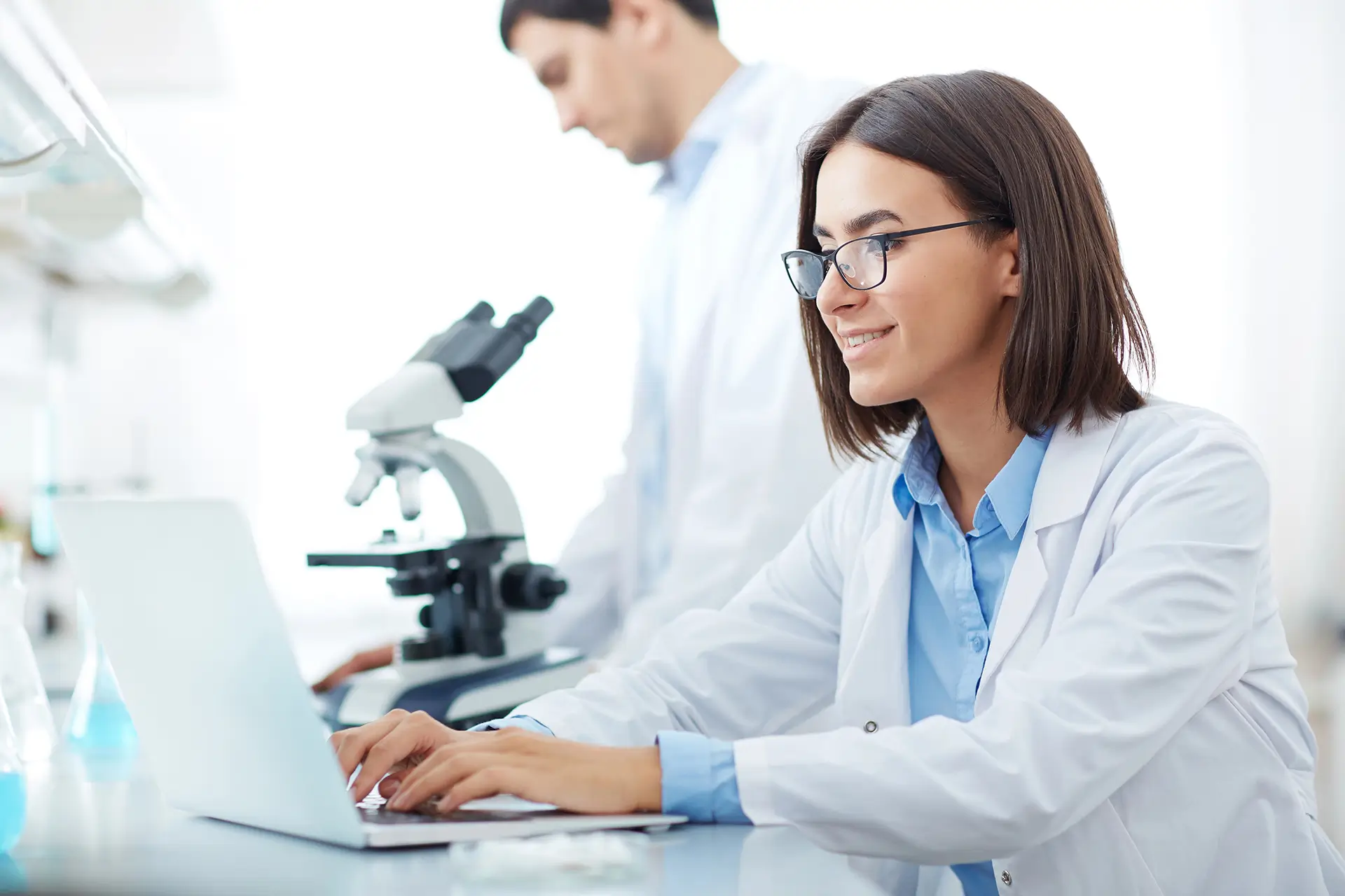 Scientist working on a laptop in a lab.